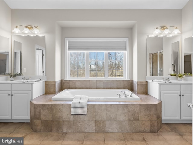 bathroom with vanity, tiled tub, and tile patterned floors