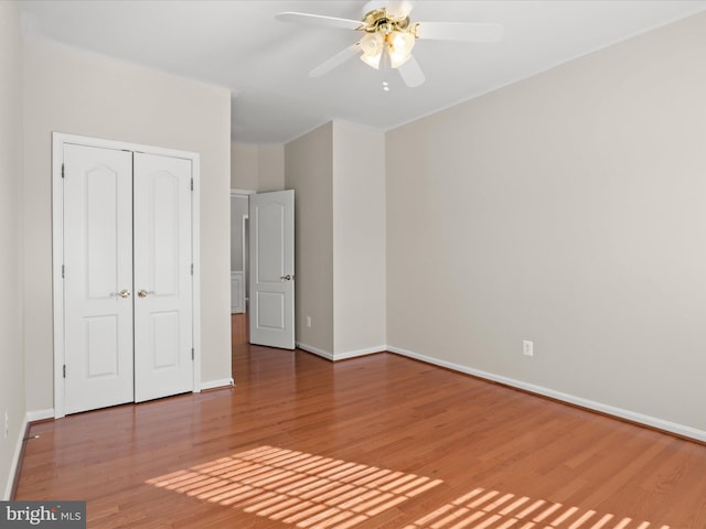 unfurnished bedroom featuring hardwood / wood-style flooring, ceiling fan, and a closet