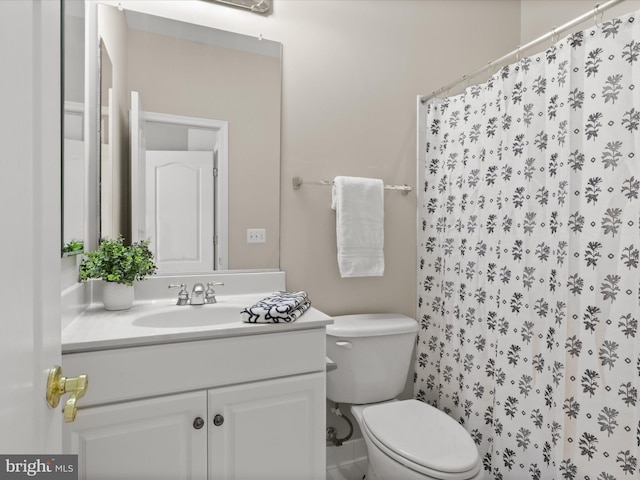 bathroom with walk in shower, vanity, and toilet