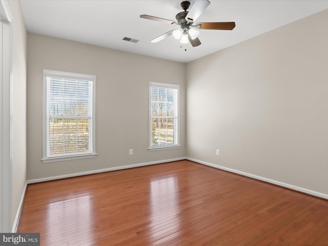 spare room with hardwood / wood-style flooring, ceiling fan, and a wealth of natural light