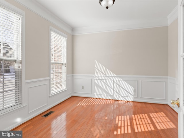 spare room featuring crown molding and light hardwood / wood-style flooring