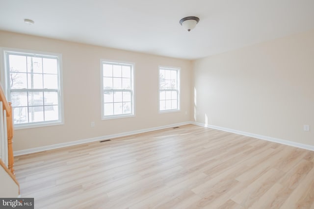 spare room featuring a healthy amount of sunlight and light hardwood / wood-style flooring