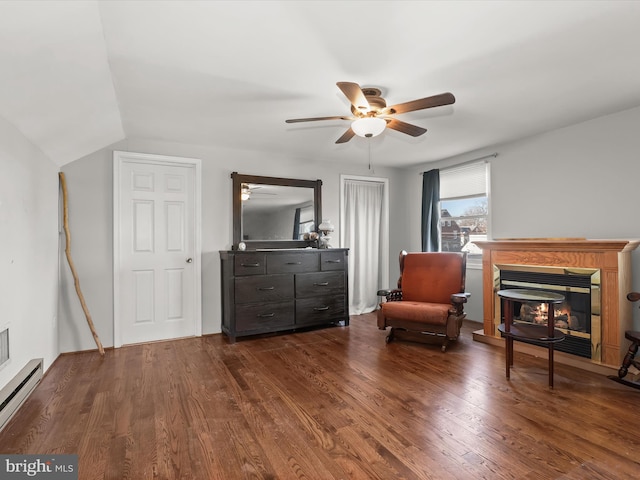 living area featuring ceiling fan, vaulted ceiling, dark hardwood / wood-style flooring, and baseboard heating