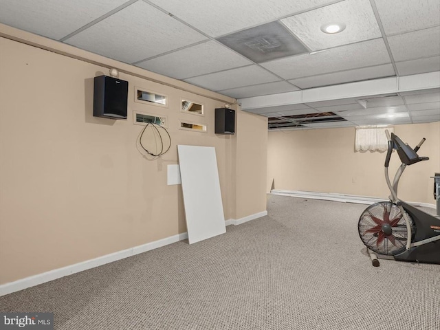 workout room with a paneled ceiling and carpet