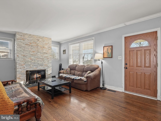 living room featuring crown molding, dark wood-type flooring, and a fireplace