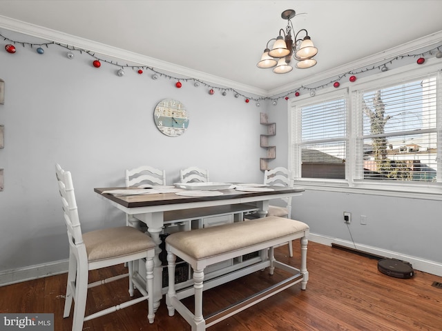 dining area featuring an inviting chandelier, dark hardwood / wood-style floors, and crown molding