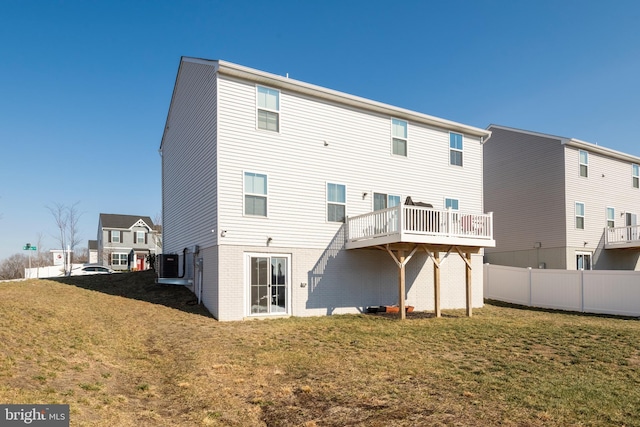 rear view of house with a wooden deck and a yard