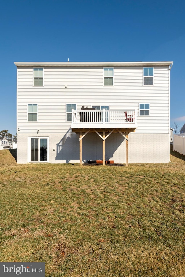 back of property with a deck and a lawn