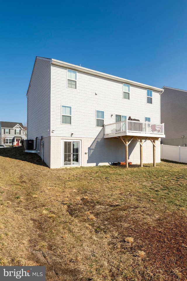 rear view of house featuring a lawn and central air condition unit