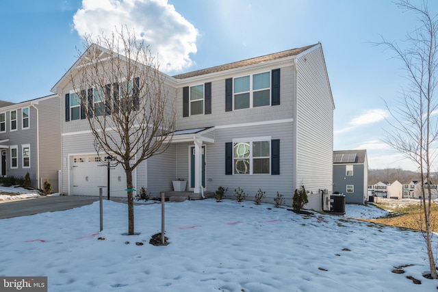 view of front of home featuring cooling unit and a garage