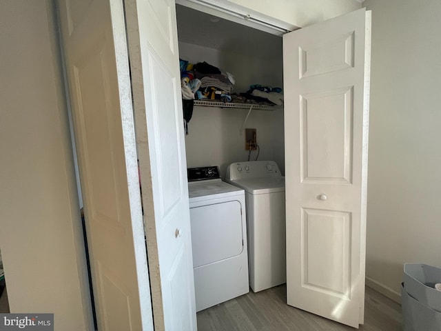 laundry room with independent washer and dryer and light hardwood / wood-style floors