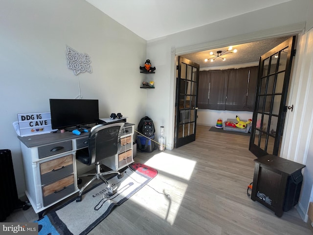 home office with light hardwood / wood-style floors and french doors