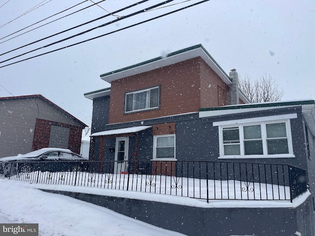 view of snow covered rear of property