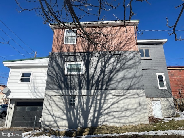 view of snow covered exterior with a garage