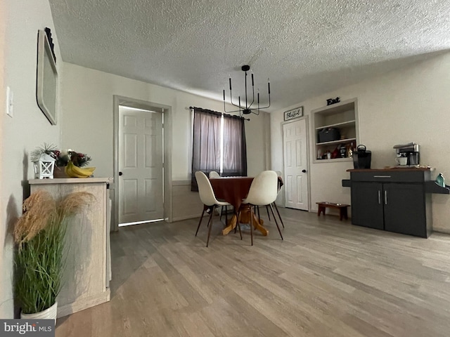 dining room with hardwood / wood-style flooring, built in features, and a textured ceiling