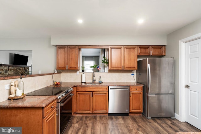 kitchen featuring dark wood-type flooring, sink, stone countertops, appliances with stainless steel finishes, and backsplash