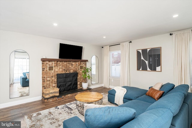 living room featuring hardwood / wood-style floors and a brick fireplace