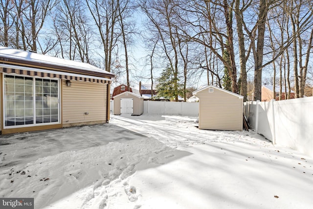 yard covered in snow featuring a shed