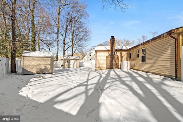 snowy yard with a shed