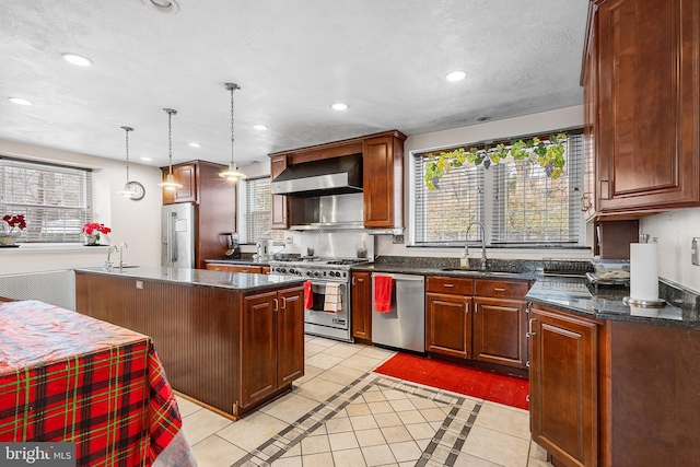 kitchen featuring light tile patterned flooring, wall chimney exhaust hood, a center island, and premium appliances