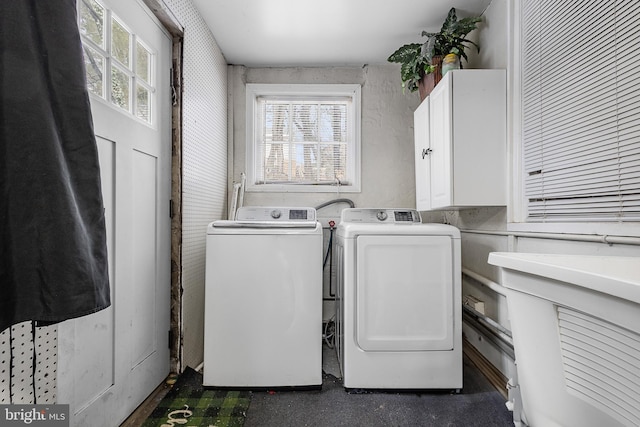 clothes washing area featuring washer and clothes dryer and cabinets