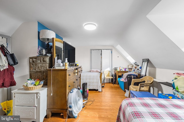 bedroom featuring hardwood / wood-style flooring and lofted ceiling