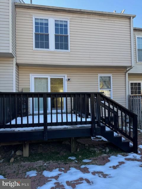 snow covered house featuring a deck