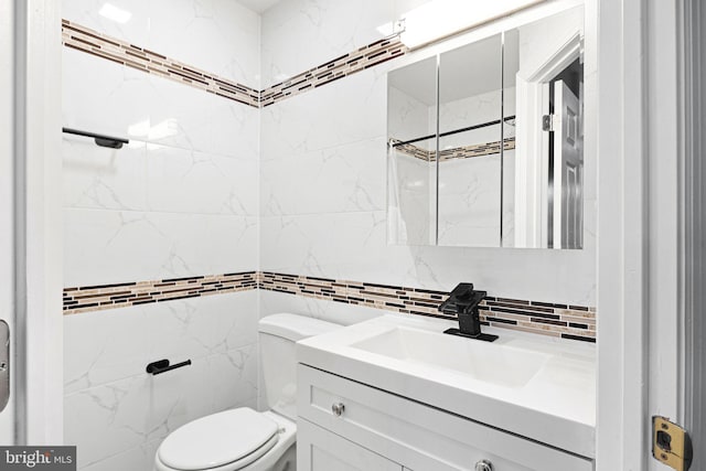 bathroom with vanity, decorative backsplash, and toilet