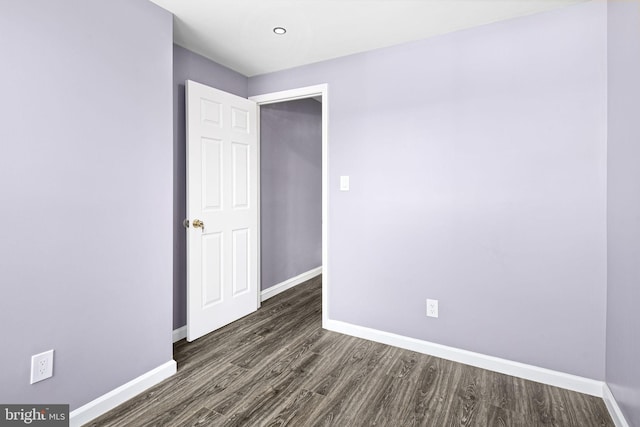 unfurnished room featuring dark wood-type flooring