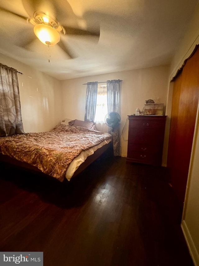 bedroom featuring dark hardwood / wood-style floors, a textured ceiling, and ceiling fan