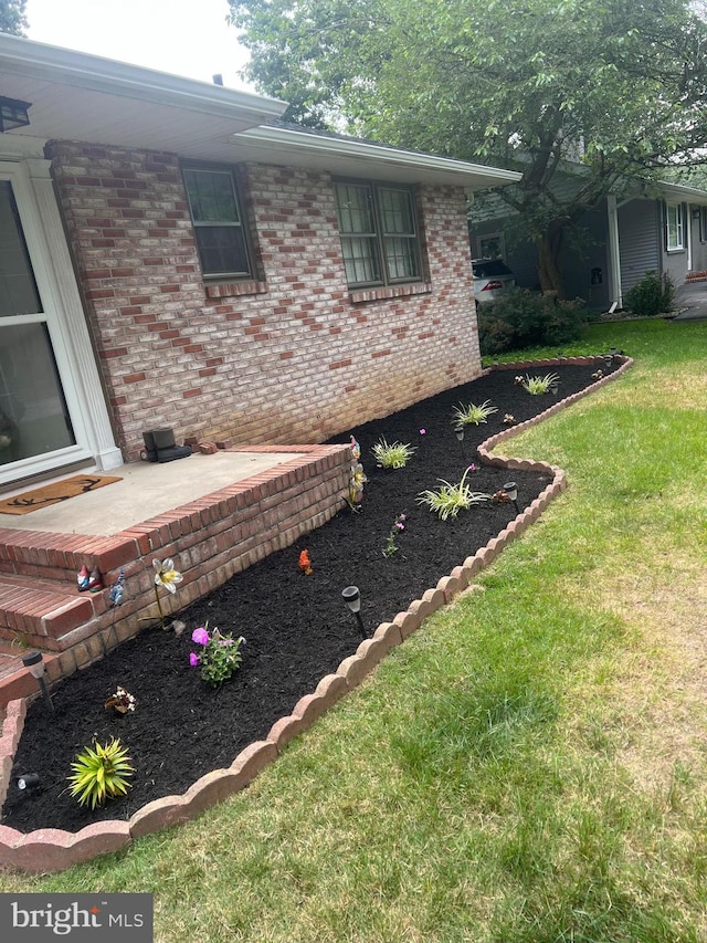 view of side of home with a yard and a patio area