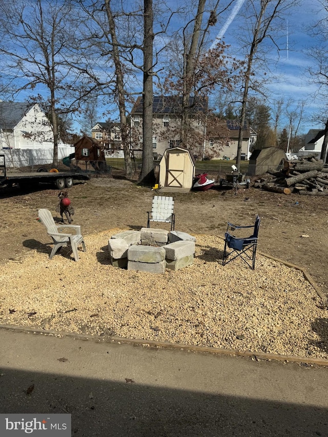 view of yard with a shed and an outdoor fire pit