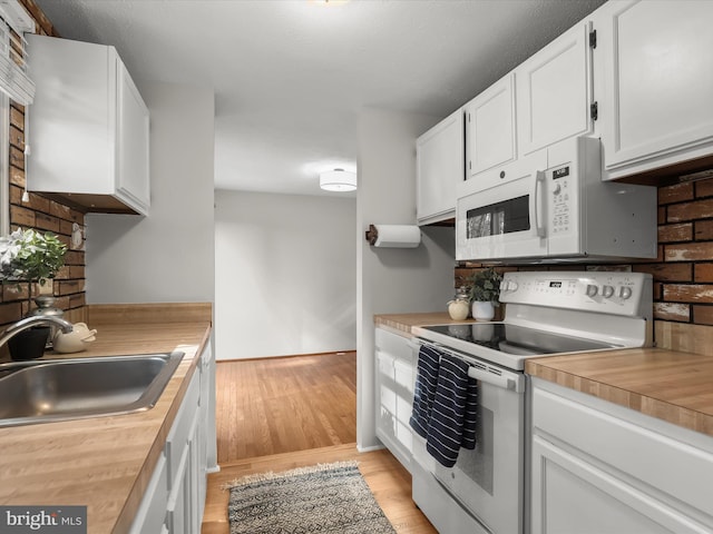 kitchen featuring wood counters, sink, white cabinetry, light wood-type flooring, and white appliances