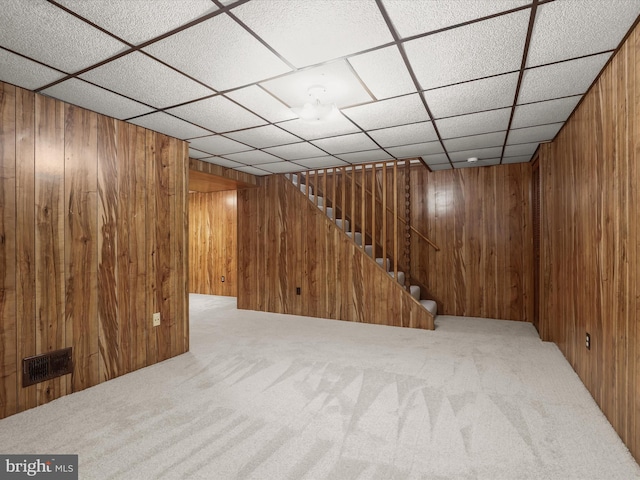 basement with carpet floors and wood walls