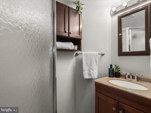 bathroom featuring vanity and a shower with shower door