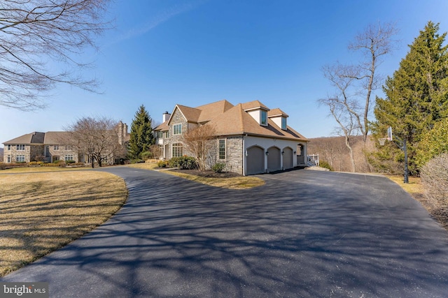 view of home's exterior with aphalt driveway, stone siding, and stucco siding