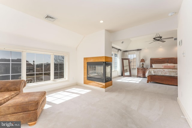 unfurnished bedroom featuring visible vents, baseboards, carpet, a multi sided fireplace, and vaulted ceiling