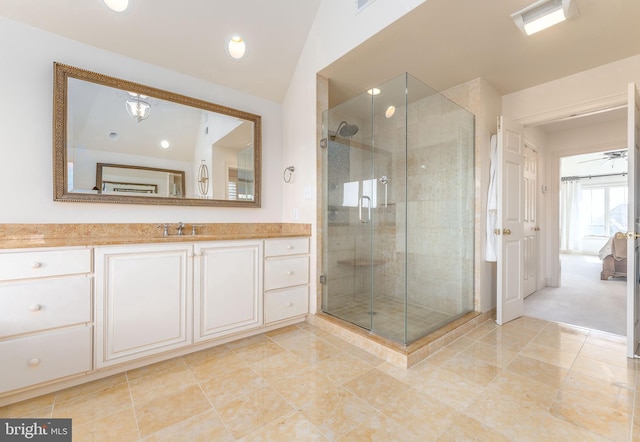 full bath with vanity, a shower stall, and lofted ceiling