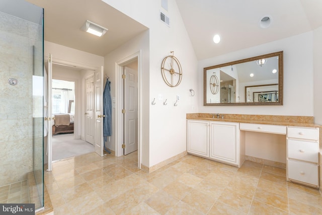 ensuite bathroom featuring vanity, baseboards, a tile shower, vaulted ceiling, and ensuite bathroom