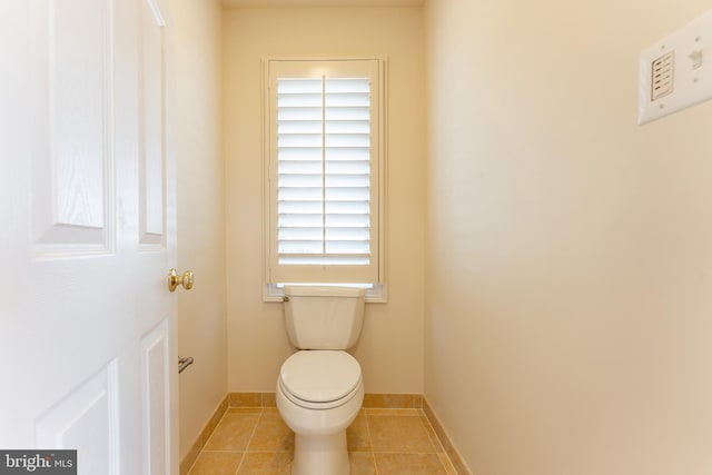 bathroom featuring tile patterned flooring, toilet, and baseboards