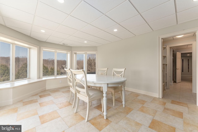 dining space featuring recessed lighting, a paneled ceiling, and baseboards