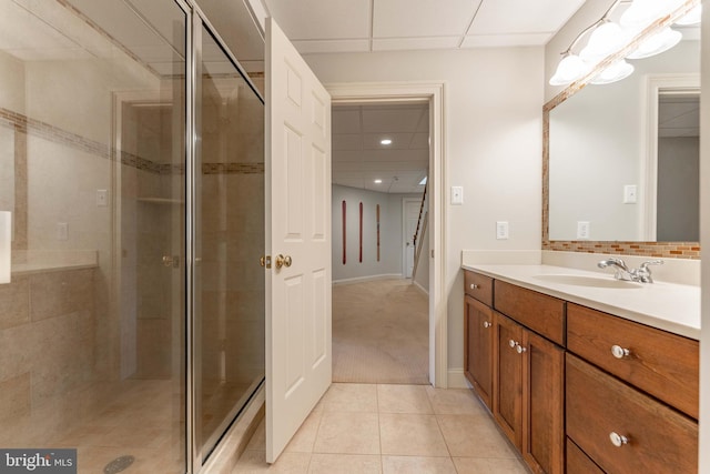 bathroom featuring vanity, tile patterned flooring, a shower stall, a paneled ceiling, and backsplash