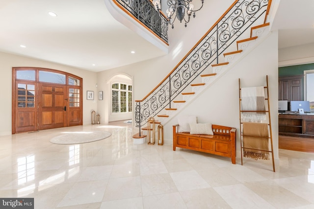 foyer featuring recessed lighting, stairway, baseboards, and a towering ceiling