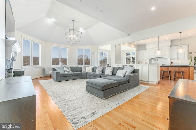 living area with baseboards, light wood-style flooring, recessed lighting, vaulted ceiling, and a chandelier