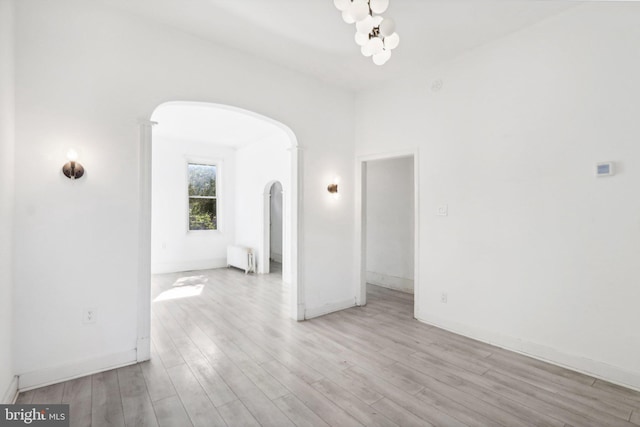 empty room featuring radiator and light hardwood / wood-style floors