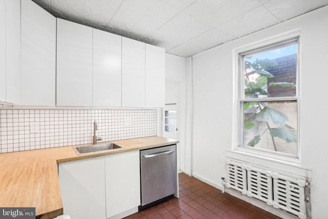 kitchen with tasteful backsplash, sink, white cabinets, and dishwasher