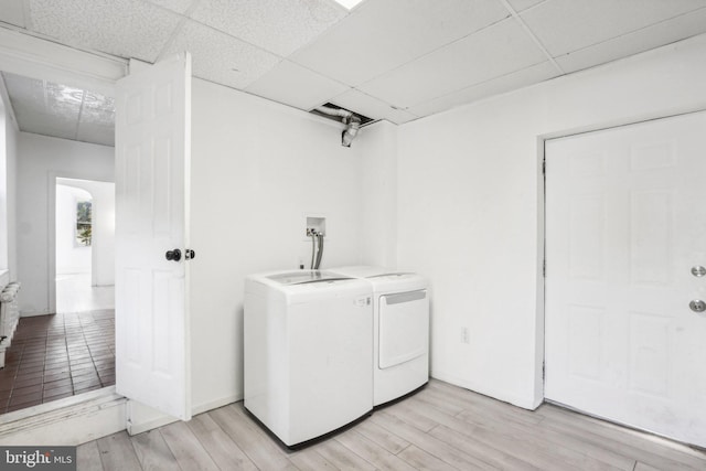 laundry room with light hardwood / wood-style floors and washing machine and dryer