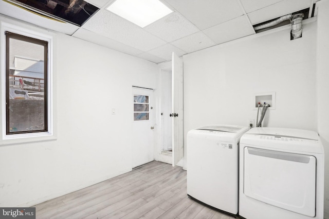 laundry room with light hardwood / wood-style floors and washer and dryer