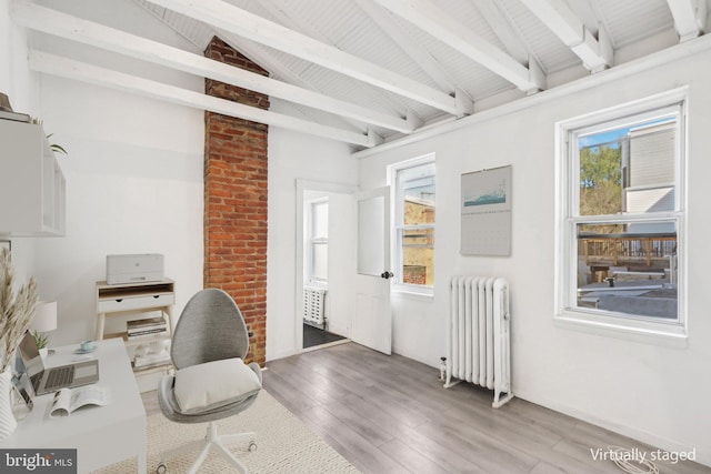 office with radiator, lofted ceiling with beams, and hardwood / wood-style floors