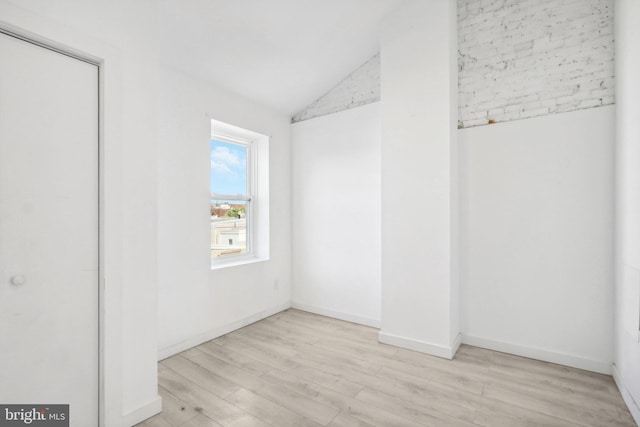 unfurnished bedroom with lofted ceiling, a closet, and light wood-type flooring